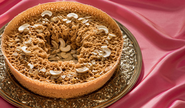 Traditional Ghevar, a famous sweet in Jaipur, made with flour, ghee, and soaked in sugar syrup.